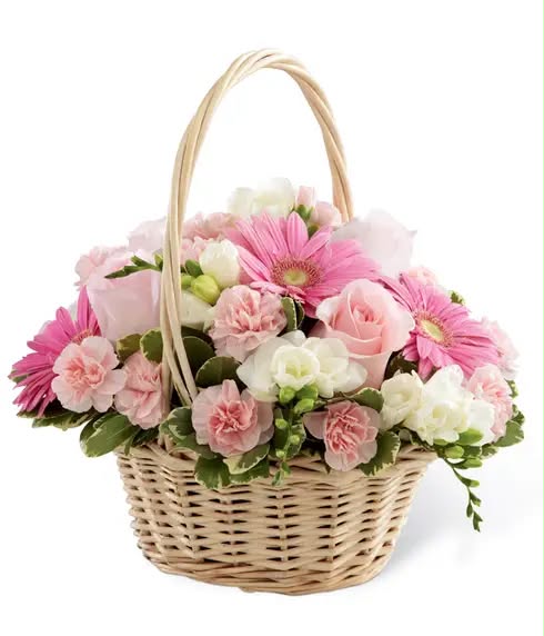 A cheerful mix of pink gerberas, carnations and roses in a wicker basket