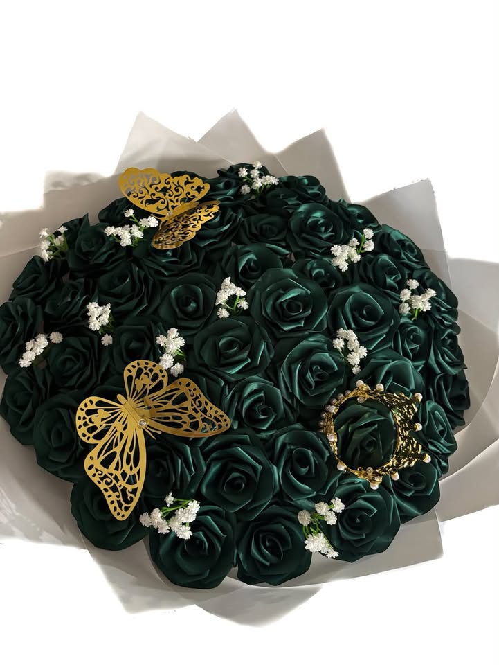 A lush dark green foam rose bouquet with gold butterfly decorations and baby's breath